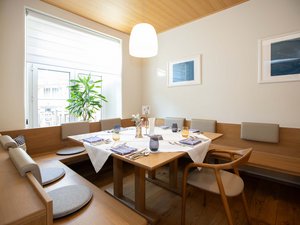 Seminarhotel Böhlerstern: die wichtigsten Infos zum Download Gemütliche Eckbank mit Holztisch und gedecktem Tisch in hellem Raum