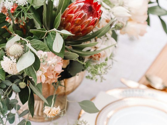 Private Feiern im Hotel Böhlerstern Blumengesteck mit roter Protea auf elegant gedecktem Tisch