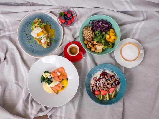 Private Feiern im Hotel Böhlerstern Verschiedene Frühstücksgerichte mit Obst, Ei, Kaffee und Joghurt auf grauem Tuch