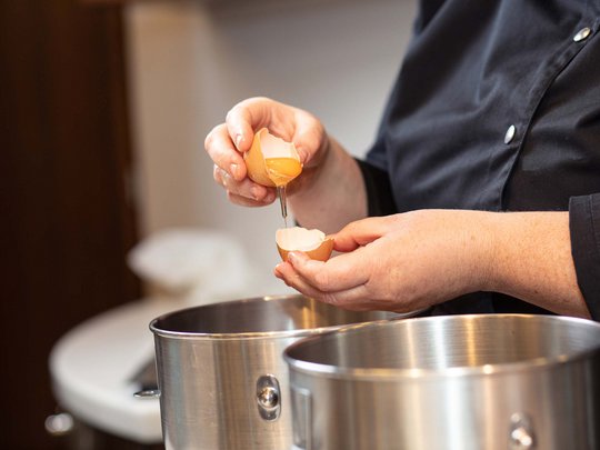 Seminar rooms at Hotel Böhlerstern: our Genusslabor® Person cracking an egg over a stainless steel bowl
