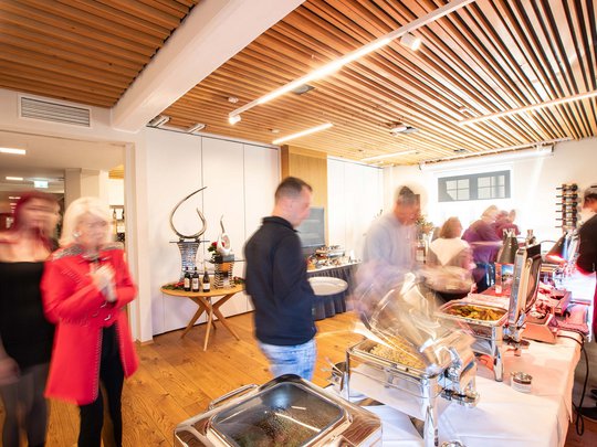 Private Feiern im Hotel Böhlerstern Buffet mit Essen und verschwommenen Menschen in einem gut beleuchteten Raum