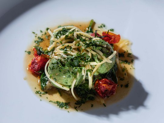 Seminar rooms at Hotel Böhlerstern: our Genusslabor® Spinach dumplings with herbs, roasted tomatoes, and spaghetti on a white plate
