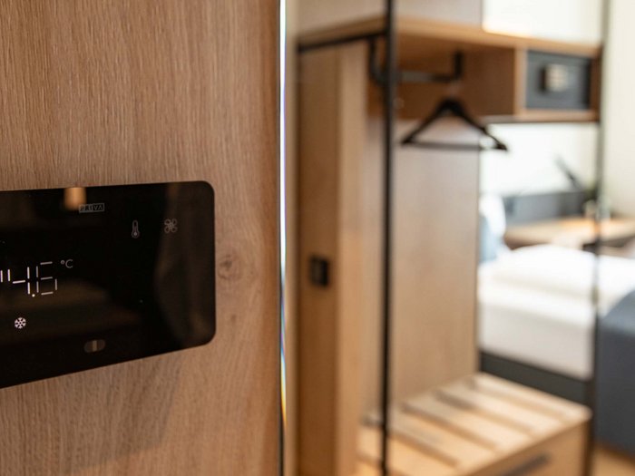 Hotel Böhlerstern in der Steiermark: unsere Zimmer Digitale Temperaturanzeige im Zimmer neben einem Kleiderschrank