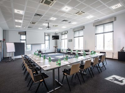 Hotel Böhlerstern: Ihr Seminarhotel in der Steiermark Großer Konferenzraum mit Tischen in U-Form, Stühlen, Wasserflaschen und Schreibmaterial