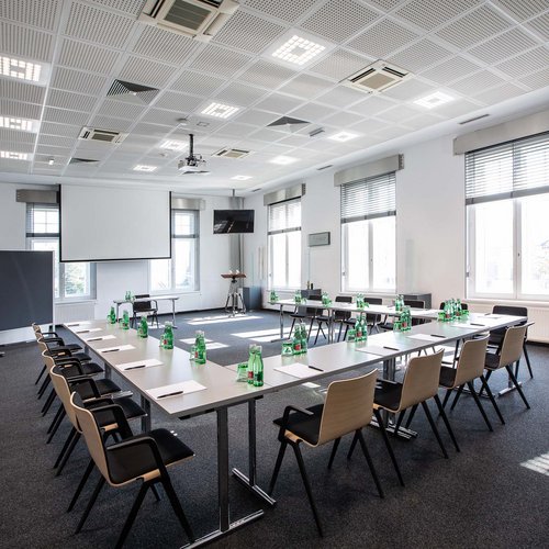 Hotel Böhlerstern Kapfenberg: Veranstaltungen und Seminare Großer Konferenzraum mit Tischen in U-Form, Stühlen, Wasserflaschen und Schreibmaterial