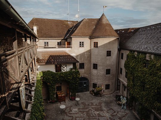 Our tips: the best trips in Styria Courtyard of a historic castle with cobblestone floor and ivy-covered walls