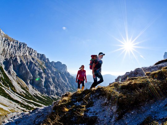 Our tips: the best trips in Styria Two hikers climbing a sunny mountain trail in the Alps