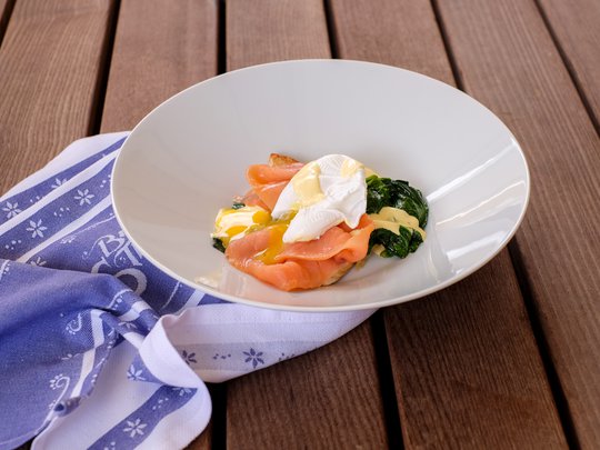 Private Feiern im Hotel Böhlerstern Teller mit pochiertem Ei, Räucherlachs, Spinat und Hollandaise auf Holzuntergrund