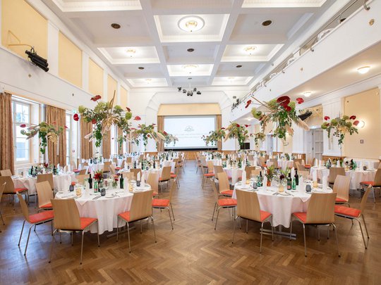 Seminarräume im Hotel Böhlerstern: der Theatersaal Festlich gedeckte Tische mit Blumenarrangements in einem großen, hellen Festsaal