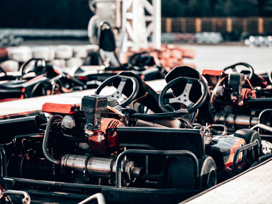 Ideen für Teambuilding mit Übernachtung Mehrere geparkte Kartfahrzeuge im Freien an einer Rennstrecke