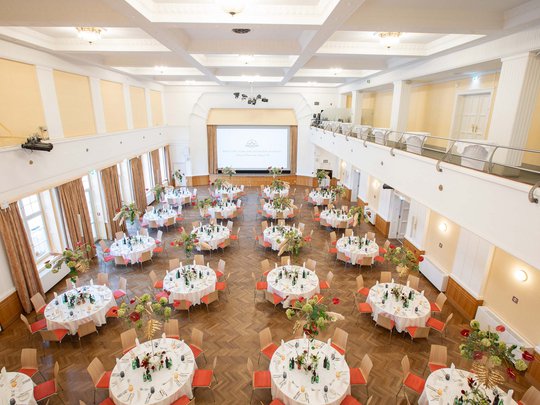 Private Feiern im Hotel Böhlerstern Großer festlicher Saal mit rund gedeckten Tischen und Blumenarrangements