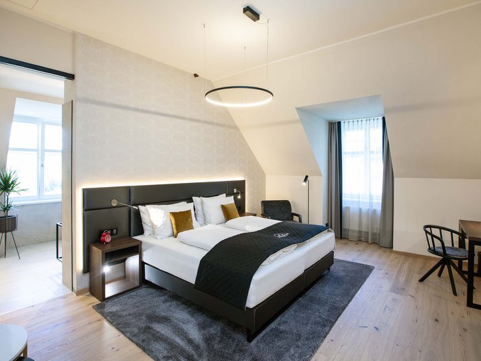 Hotel Böhlerstern in der Steiermark: unsere Zimmer Modernes Hotelzimmer mit Doppelbett, Schreibtisch und Badezimmer mit Pflanzen