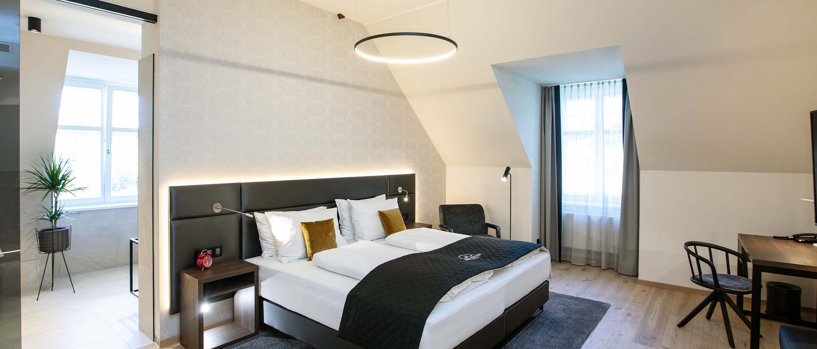 Executive Room Modernes Hotelzimmer mit Doppelbett, Schreibtisch und Badezimmer mit Pflanzen