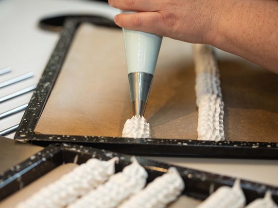 Seminar rooms at Hotel Böhlerstern: our Genusslabor® Hand piping meringue mixture onto baking paper on a tray