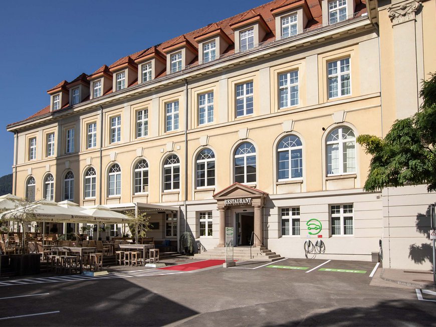 Ihr Urlaub in der Steiermark Historisches Gebäude mit Restaurant und Außenbereich mit Tischen und Sonnenschirmen