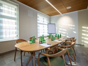 Seminarhotel Böhlerstern: die wichtigsten Infos zum Download Heller Konferenzraum mit Holztisch, Stühlen, Wasserflaschen, Zetteln und Flipchart