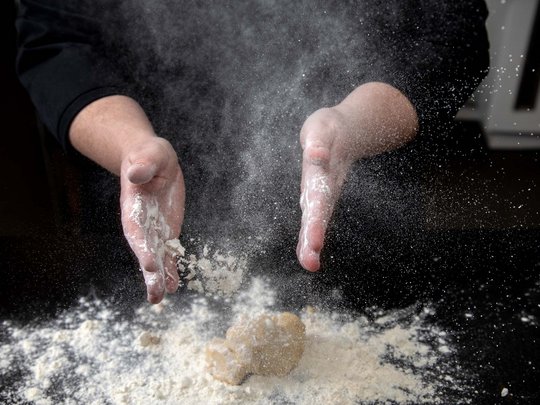 Seminar rooms at Hotel Böhlerstern: our Genusslabor® Hands dusting flour over dough on a black surface