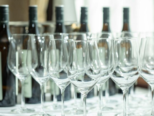 Private Feiern im Hotel Böhlerstern Mehrere leere Weingläser mit Weinflaschen im Hintergrund auf einem Tisch