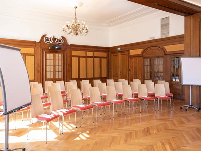 Seminar rooms at Hotel Böhlerstern: club room Empty conference room with chairs, flipcharts, and wood paneling