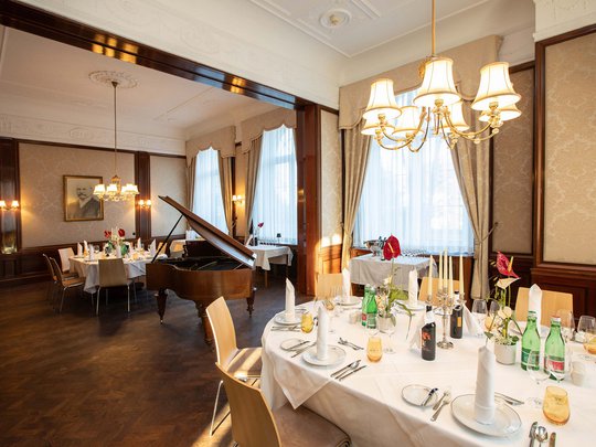 Private Feiern im Hotel Böhlerstern Elegantes Speisezimmer mit gedecktem Tisch und Flügel in historischem Ambiente