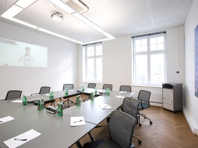 Meetingroom S600 Conference room with tables, chairs, water bottles, and a wall projector