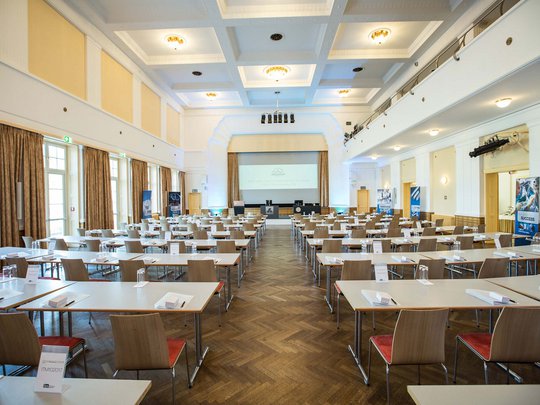 Seminarräume im Hotel Böhlerstern: der Theatersaal Hell beleuchteter Konferenzraum mit Tischen, Stühlen und Projektionsleinwand