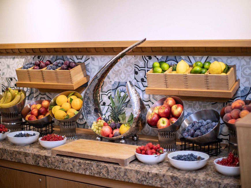 Bachstelze restaurant in Kapfenberg Variety of fruits in bowls and wooden boxes on kitchen counter with patterned tiles