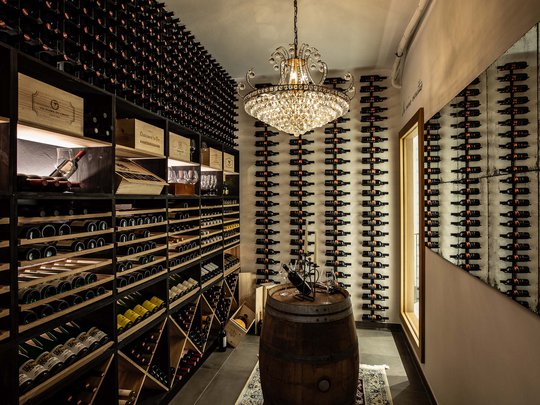 Seminar rooms at Hotel Böhlerstern: our Genusslabor® Wine cellar with wooden racks, wine bottles, and a chandelier