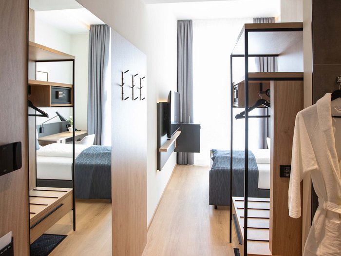 Hotel Böhlerstern in der Steiermark: unsere Zimmer Moderner Hotelzimmerflur mit großem Spiegel und offenem Garderobenbereich