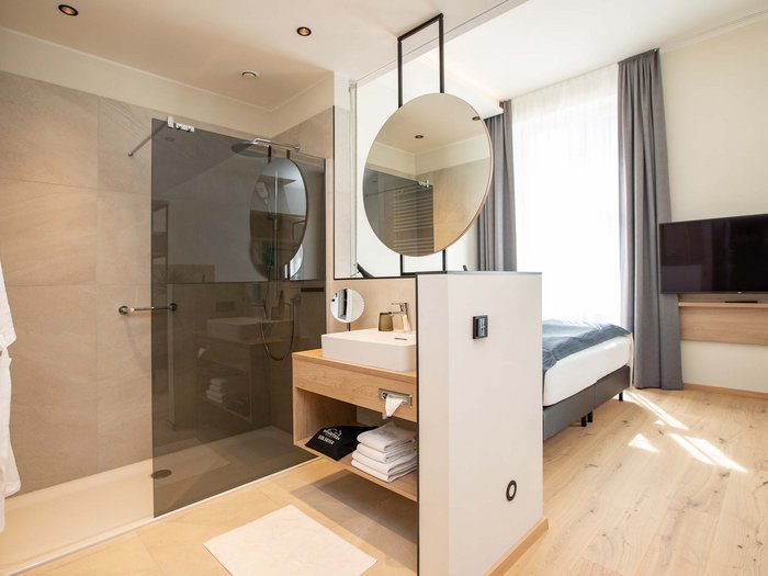 Hotel Böhlerstern in der Steiermark: unsere Zimmer Modernes Hotelzimmer mit offenem Badezimmer und Dusche