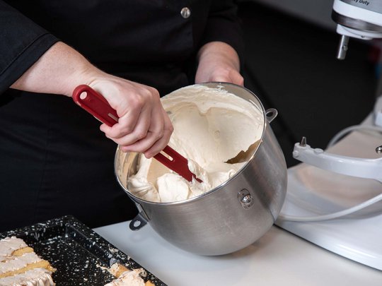 Seminar rooms at Hotel Böhlerstern: our Genusslabor® Person stirring cake batter in large metal bowl with spatula