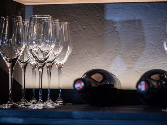 Seminar rooms at Hotel Böhlerstern: our Genusslabor® Several empty wine glasses next to two lying wine bottles on a shelf