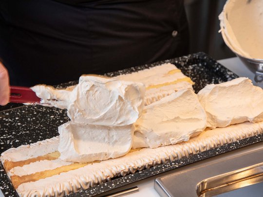 Seminar rooms at Hotel Böhlerstern: our Genusslabor® Person spreading cream on sheet cake with spatula