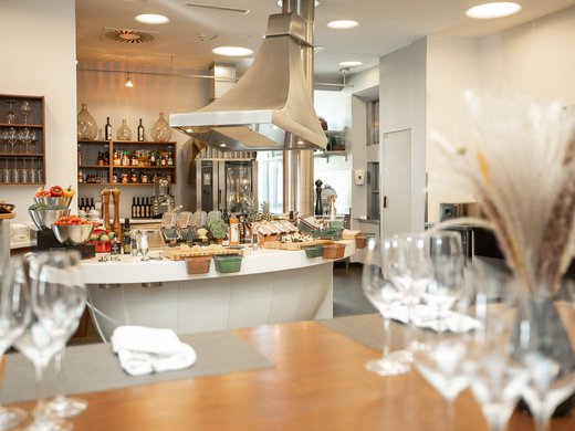 Böhlerstern: das Hotel in Kapfenberg für Seminare und Veranstaltungen Moderne offene Küche mit Besteck, Weinflaschen und frischem Gemüse auf der Arbeitsfläche