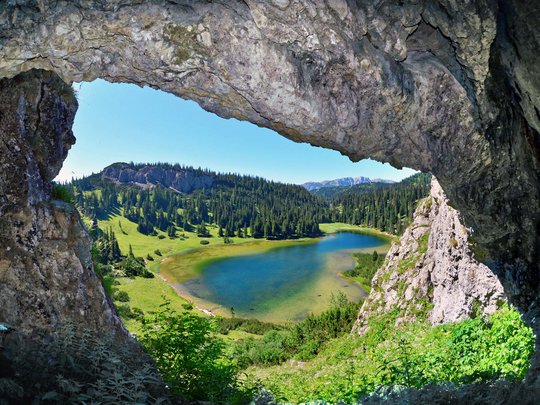 Our tips: the best trips in Styria View of a lake and forest through a cave opening