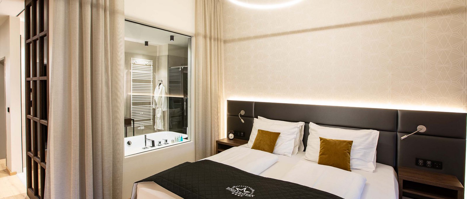 Executive Room Modernes Hotelzimmer mit Doppelbett und Badezimmer durch Glaswand sichtbar