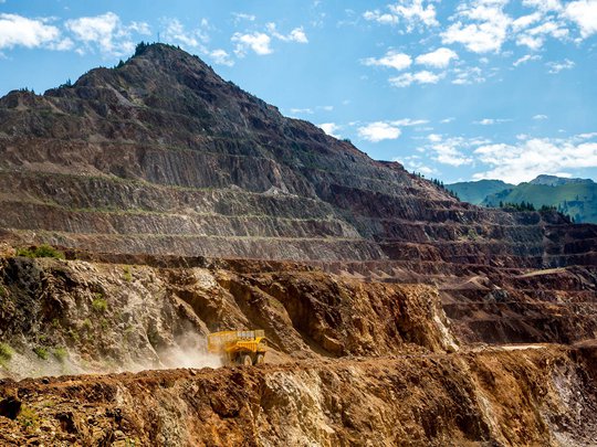 Our tips: the best trips in Styria Large dump truck driving in open-pit mine with steep mountain and blue sky