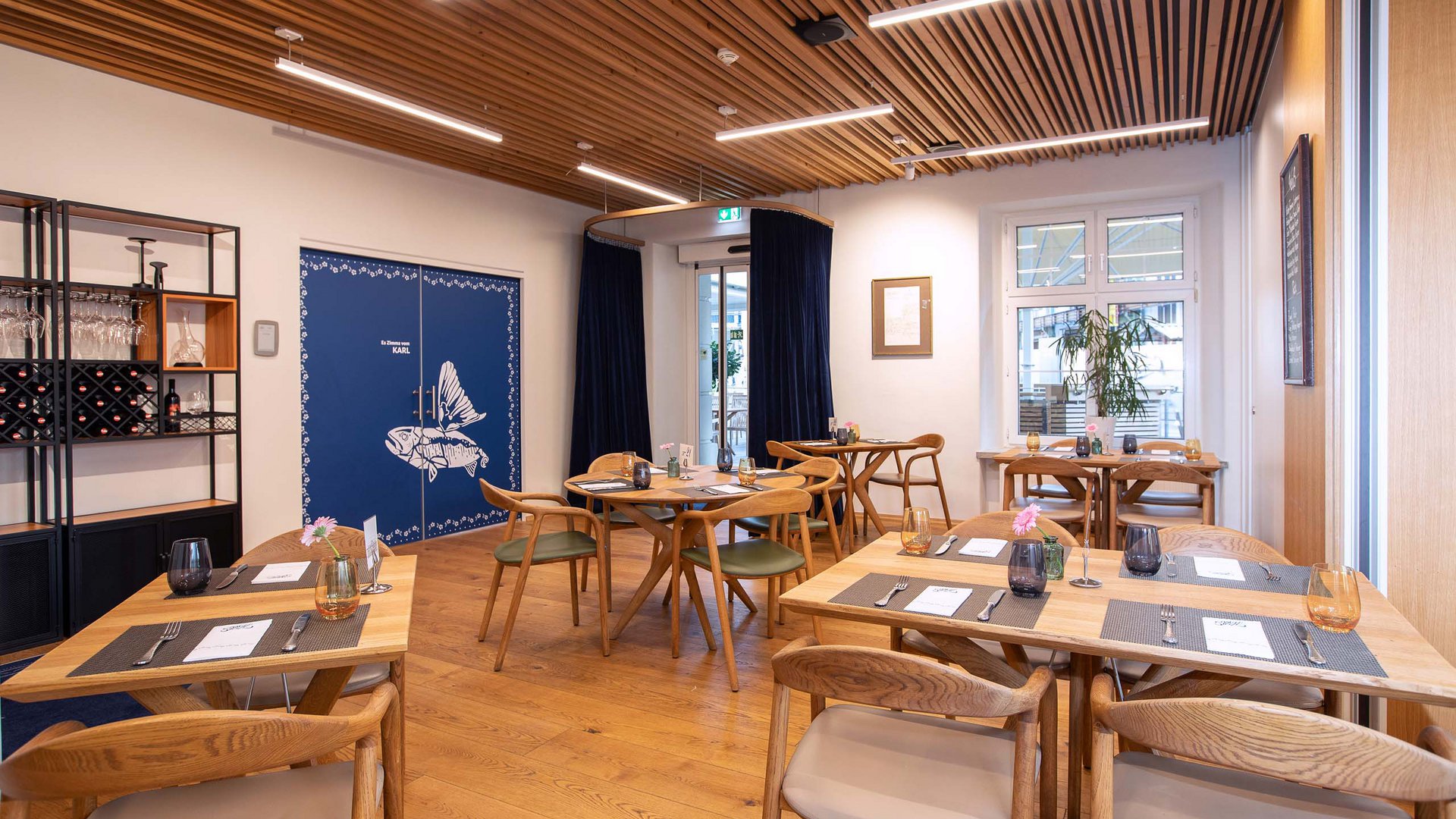 Seminarräume im Hotel Böhlerstern: Karl Modern eingerichtetes Restaurant mit Holzmöbeln und blauen Vorhängen