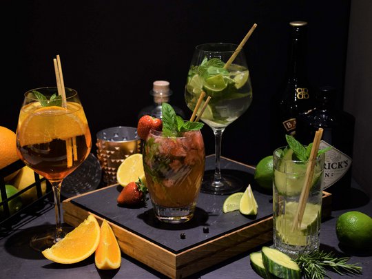 Private Feiern im Hotel Böhlerstern Vier bunte Cocktails mit Früchten und Kräutern auf schwarzem Untergrund