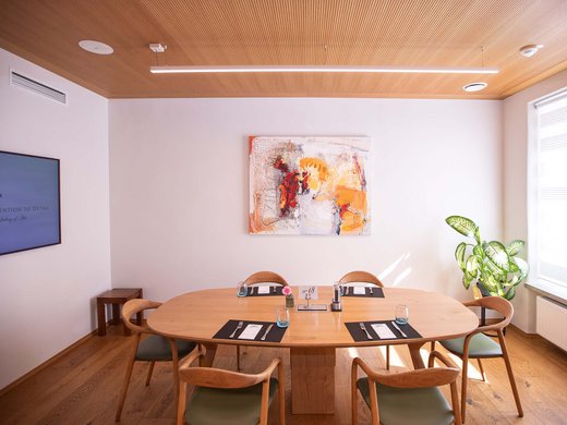 Böhlerstern: das Hotel in Kapfenberg für Seminare und Veranstaltungen Essbereich mit ovalem Holztisch, sechs Stühlen und moderner Kunst an der Wand