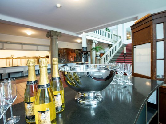 Seminarräume im Hotel Böhlerstern: der Theatersaal Champagnerflaschen und Gläser auf dunklem Tresen in einem eleganten Innenraum