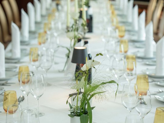 Hotel Böhlerstern: the dining room in the  Fürstentrakt Elegantly set long table with white napkins and flower centerpieces