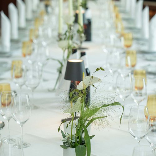 Hotel Böhlerstern Kapfenberg: Veranstaltungen und Seminare Festlich gedeckter langer Tisch mit weißen Servietten und Blumen in Vase