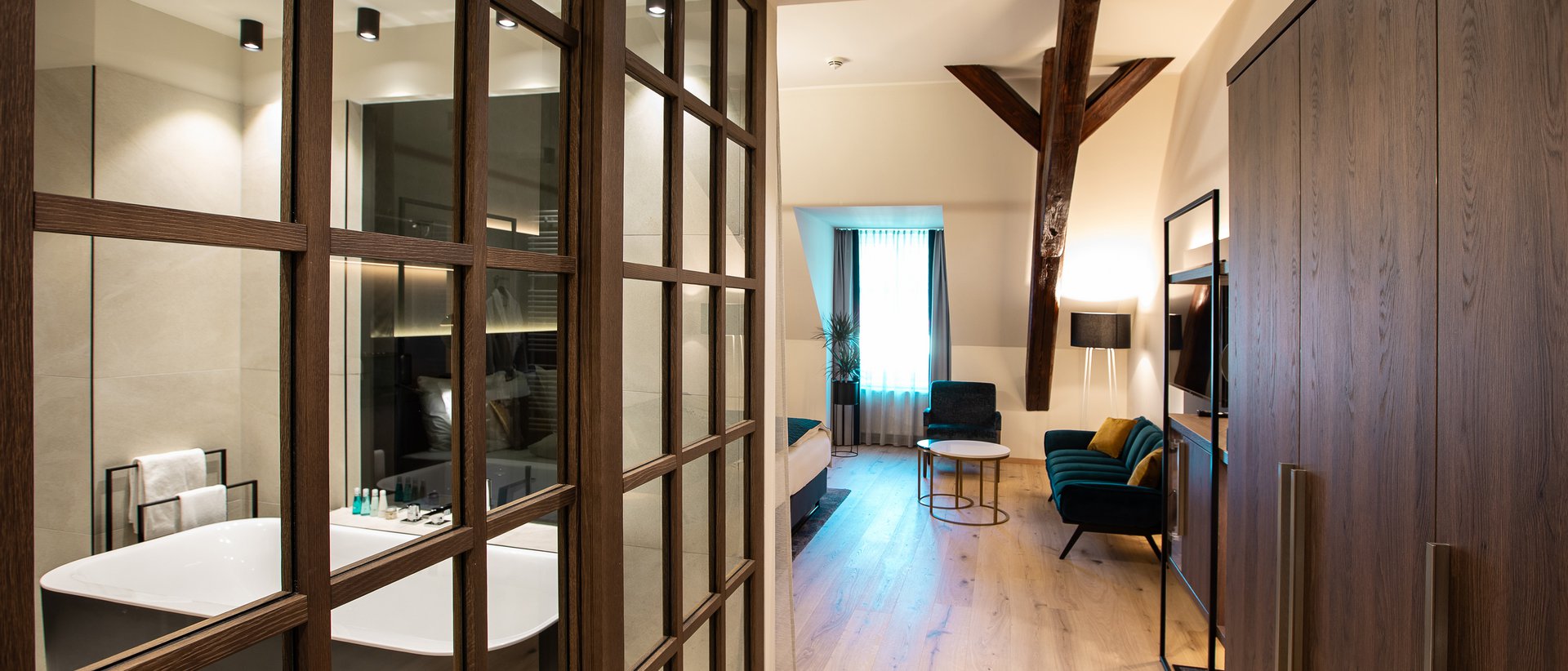 Zimmerbuchung 2025 Modernes Hotelzimmer mit freistehender Badewanne und Sitzbereich mit Sofa