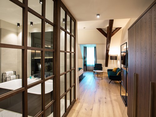 EARLY BIRD DEAL Modern hotel room with freestanding bathtub and seating area with sofa