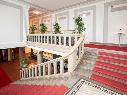 Seminarräume im Hotel Böhlerstern: der Theatersaal Elegante Treppe mit rotem Teppich und weißen Wänden im Gebäudeinneren